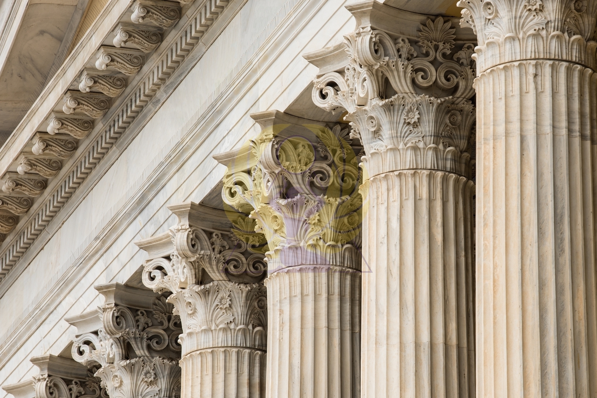 Ряд декоративных капителей  из стеклопластика с имитацией белого мрамора, выстроенных в линию на светлой поверхности.